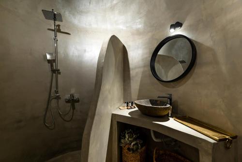 a bathroom with a sink and a mirror at Lami Traditional Windmill - With Private pool and Jacuzzi in Pirgos