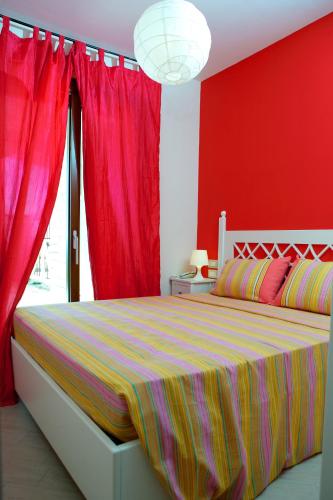 a bedroom with a large bed with red walls at Holiday Lodge al Porto in Mattinata