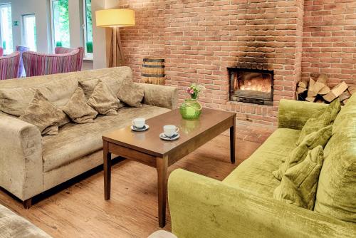 a living room with a couch and a fireplace at Citi Hotel's Warszawa-Falenty in Raszyn