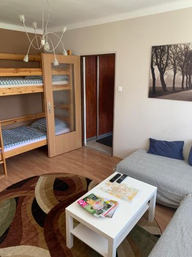 a living room with a couch and a table and bunk beds at Apartament T&Hos in Trnava