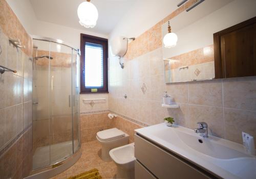 La salle de bains est pourvue de toilettes, d'un lavabo et d'une douche. dans l'établissement Villa dei Sogni Gallipoli, à Tuglie