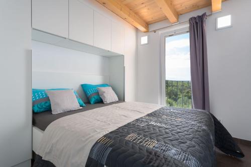 1 dormitorio con 1 cama grande y ventana en Gallery apartment in Skrbcici (Krk), en Skrbčići