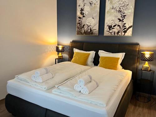 Una cama grande con dos toallas blancas. en PRAGUE’s HIDDEN PEARL, en Praga