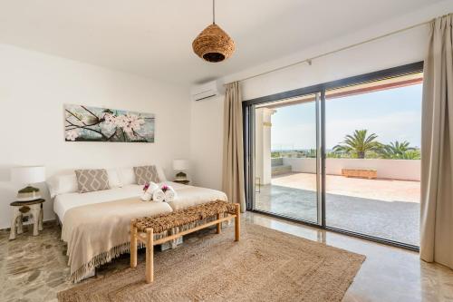 a bedroom with a bed and a large sliding glass door at Villa Can Ravi in Cala de Bou