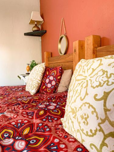 a bedroom with a bed with a wooden headboard and pillows at Havana Nights in Graskop