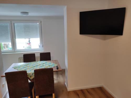 a dining room with a table and a television on a wall at Sommerresidenz 9210 in Pörtschach am Wörthersee