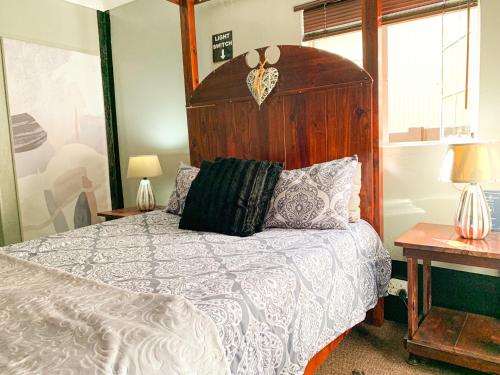 um quarto com uma cama grande e uma cabeceira em madeira em Havana Nights em Graskop