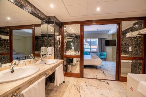 a bathroom with two sinks and a large mirror at Hotel Bahía de Vigo in Vigo