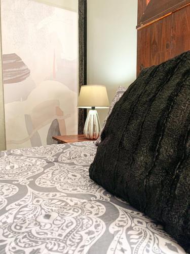 a bedroom with a bed and a lamp on a table at Havana Nights in Graskop