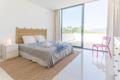 um quarto branco com uma cama e uma janela de vidro em Villa Melissa em Tróia