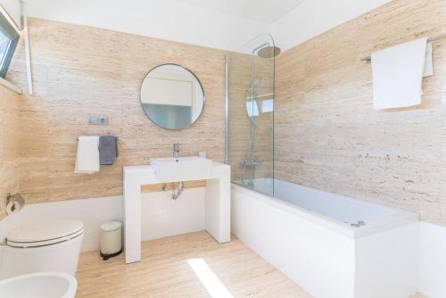 um banheiro com banheira, pia e vaso sanitário em Villa Melissa em Tróia