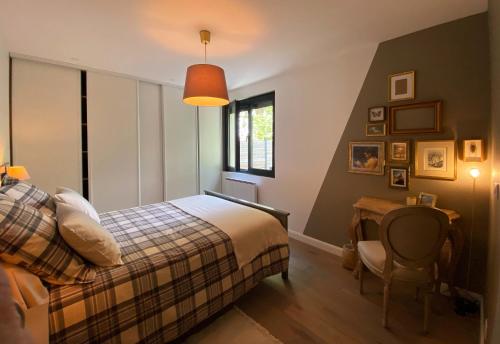Schlafzimmer mit einem Bett, einem Schreibtisch und einem Fenster in der Unterkunft La Maison du Champ de Beaumont in Galgon