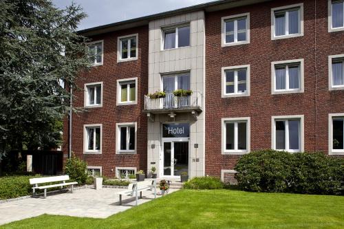 a large brick building with a lawn in front of it at Hotel Haus vom Guten Hirten in Münster