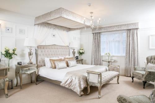a bedroom with a white bed and a chair at The Wild Boar in Bowness-on-Windermere