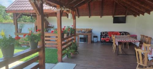 una sala de estar con un pabellón con mesa y sillas en Pensiunea Casa Mădă, en Baia de Fier