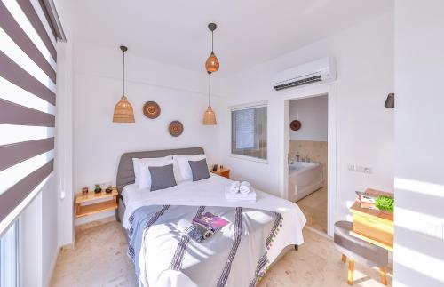 a white bedroom with a bed and a tub at Villa Ay in Kas