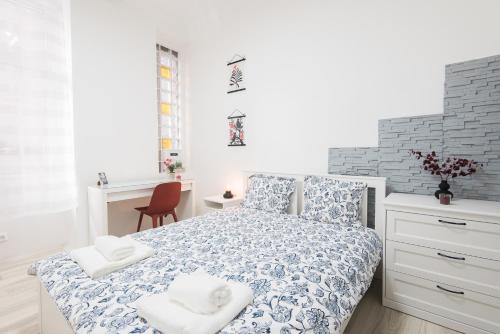 - une chambre blanche avec un lit et des serviettes dans l'établissement BUDA-PEST APARTMENT, à Budapest