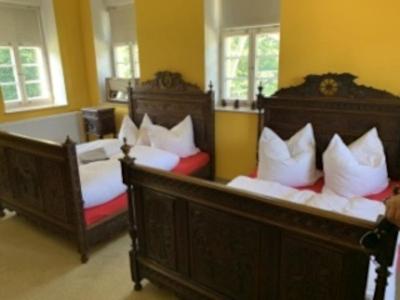 two beds with white pillows in a room at Rittergut Schloss Niederforchheim in Forchheim