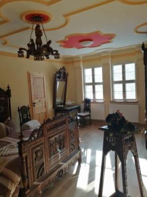 a room with a bed and a table and windows at Rittergut Schloss Niederforchheim in Forchheim