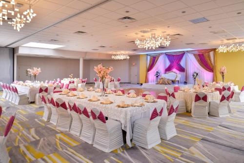 a banquet hall with tables and chairs and chandeliers at Holiday Inn Dallas-Richardson by IHG in Richardson