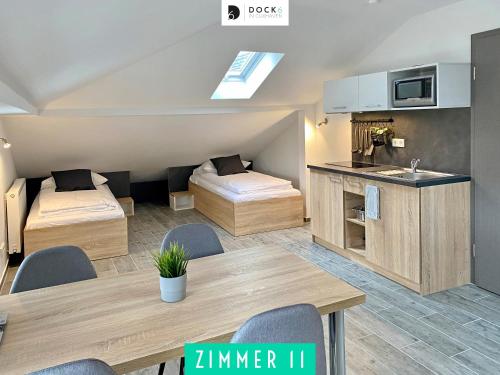 Habitación con 2 camas, mesa y cocina. en Dock 6 - Cuxhaven, en Cuxhaven