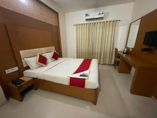 a bedroom with a large bed with a desk and a mirror at hotel green city in Chennai