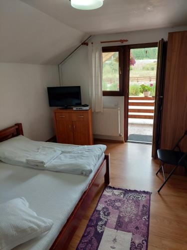 a bedroom with two beds and a sliding glass door at Green Eden Lepsa 2 in Lepşa
