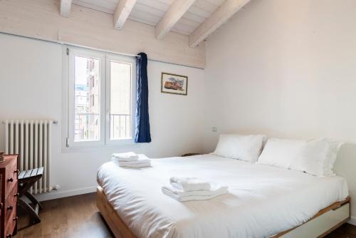 Schlafzimmer mit einem großen weißen Bett und einem Fenster in der Unterkunft LUVI - Adda in Mailand