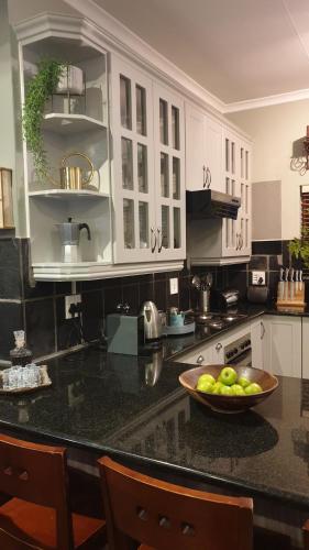 a kitchen with a bowl of fruit on a counter at Ambassador Lodge in Dullstroom