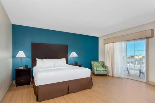 una camera con un grande letto e una parete blu di La Quinta by Wyndham Ocean City a Ocean City