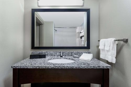 a bathroom with a sink and a large mirror at La Quinta by Wyndham Ocean City in Ocean City