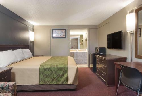 a hotel room with a bed and a bathroom at Econo Lodge Pittsburgh I-79 in Pittsburgh