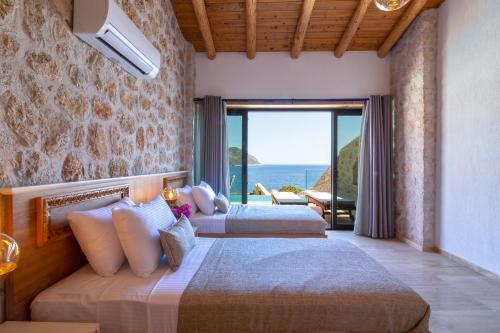 two beds in a room with a view of the ocean at Water Edge 3 in Kaş
