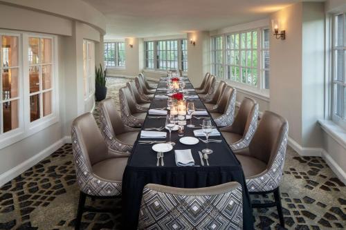 a long dining room with a long table and chairs at The Elms Hotel & Spa, a Destination by Hyatt Hotel in Excelsior Springs