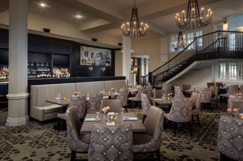 a restaurant with tables and chairs and a staircase at The Elms Hotel & Spa, a Destination by Hyatt Hotel in Excelsior Springs