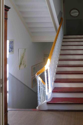 a staircase in a house with a white stair case at Gästeappartement im Atelierhaus in Wuppertal