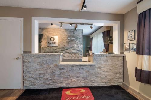 a lobby with a stone wall and a mirror at Quality Inn & Suites in Auburn