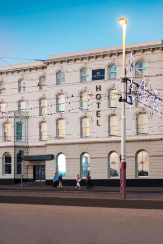 a large white building with people walking in front of it at Forshaws Hotel - Blackpool in Blackpool