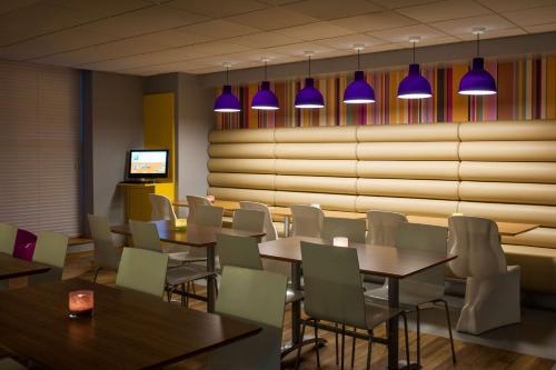 a restaurant with tables and chairs and purple lights at Forshaws Hotel - Blackpool in Blackpool