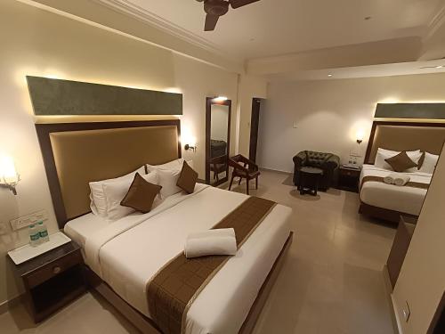 a hotel room with a large bed and a desk at Hotel Comorin Grand in Kanyakumari