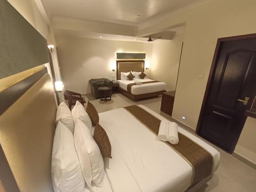 a large hotel room with a bed and a bedroom at Hotel Comorin Grand in Kanyakumari