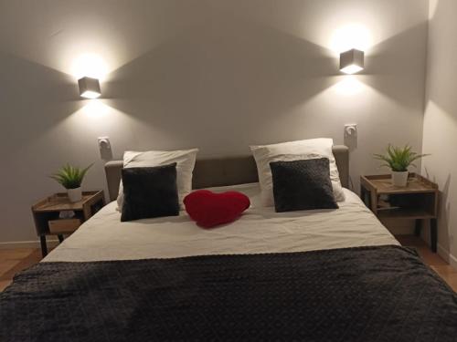 une chambre avec un lit avec un oreiller rouge dessus dans l'établissement Maison familiale avec piscine privée proche du littoral, à Candillargues