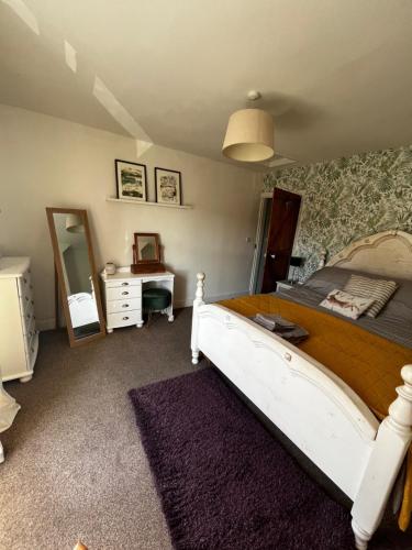 a bedroom with a bed and a dresser and a mirror at Feather and Twigs Cottage, Croston in Croston