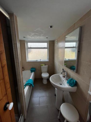 a bathroom with a sink and a tub and a toilet at Feather and Twigs Cottage, Croston in Croston