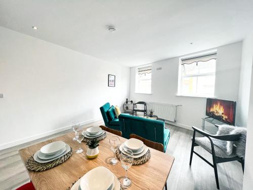 a dining room with a table and chairs and a fireplace at The County Staycation in Liverpool