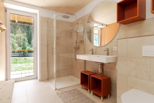 a bathroom with a shower and a sink and a mirror at NaturparkResort Lausernest in Wildalpen