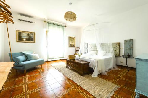 - une chambre avec un lit et une chaise bleue dans l'établissement Hostly - Il Casale dei Ninì, à San Giuliano Terme