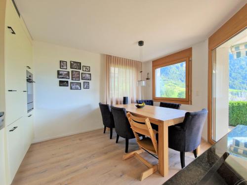 a kitchen and dining room with a wooden table and chairs at Casa Capricorn Nähe Laax in Sagogn