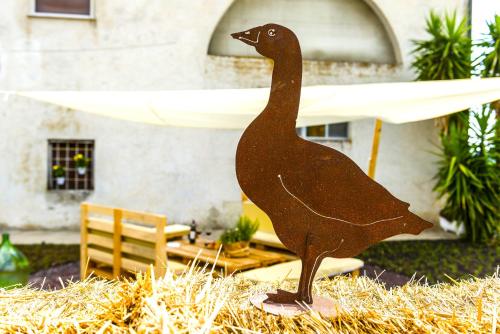 a statue of a bird on a pile of hay at Hostly - Il Casale dei Ninì in San Giuliano Terme
