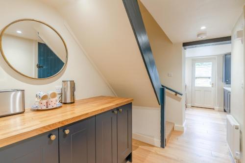a kitchen with a counter and a mirror at Vine Cottage in Charlbury